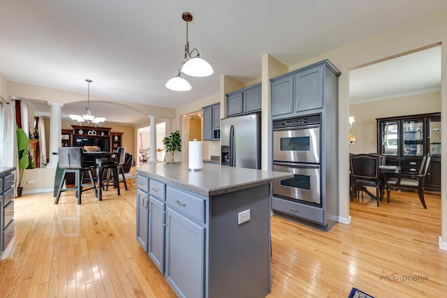 337A Veronica Cir, Bartlett, IL 60103 - kitchen featuring decorative columns, appliances with stainless steel finishes, light wood-type flooring, a center island, and hanging light fixtures