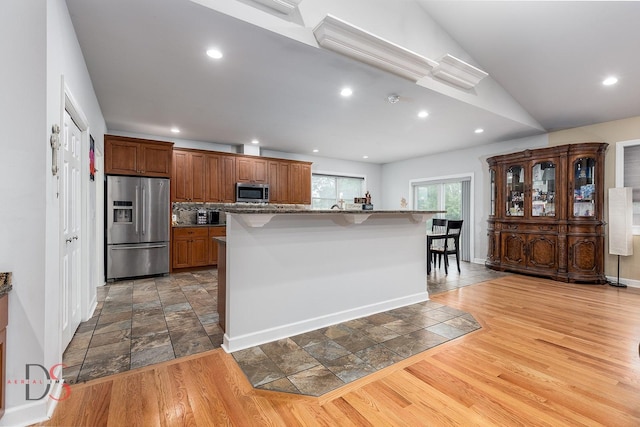 1661 Locust Rd, Morris, IL 60450 - kitchen featuring stainless steel appliances, a breakfast bar area, stone tile flooring, brown cabinets, and recessed lighting