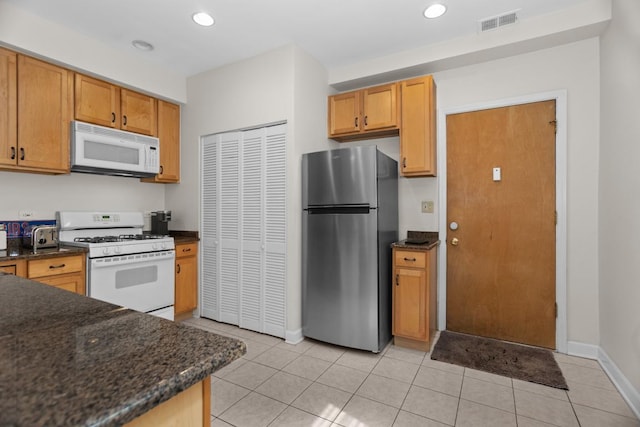 555 Elmwood Ave Unit 1, Evanston, IL 60202 - kitchen featuring white appliances, light tile patterned floors, recessed lighting, and dark stone counters