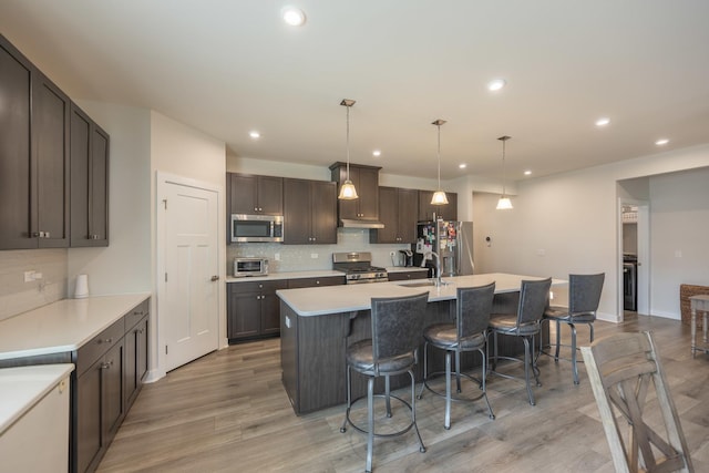 2107 Traemore Ln, New Lenox, IL 60451 - kitchen featuring appliances with stainless steel finishes, tasteful backsplash, a kitchen bar, a center island with sink, and recessed lighting