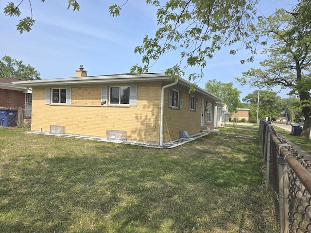 1449 Kristan Ave, North Chicago, IL 60064 - view of home's exterior featuring brick siding, a chimney, and a fenced backyard