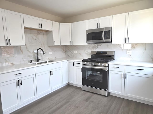 1449 Kristan Ave, North Chicago, IL 60064 - kitchen with appliances with stainless steel finishes, white cabinets, light wood-type flooring, and tasteful backsplash