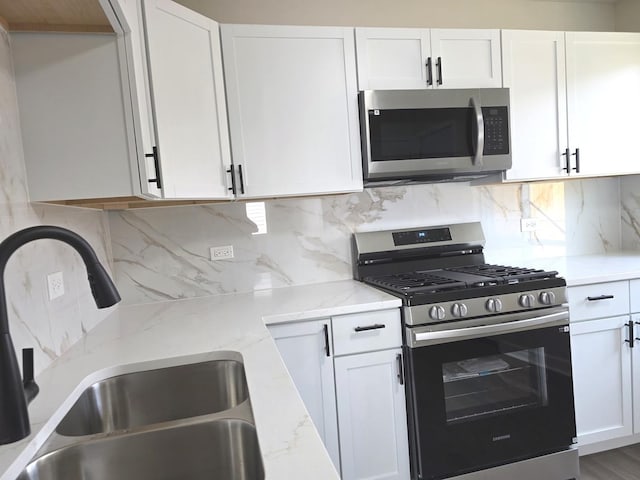 1449 Kristan Ave, North Chicago, IL 60064 - kitchen featuring stainless steel appliances, light stone countertops, and white cabinets