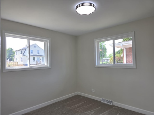 1449 Kristan Ave, North Chicago, IL 60064 - spare room featuring plenty of natural light and dark colored carpet
