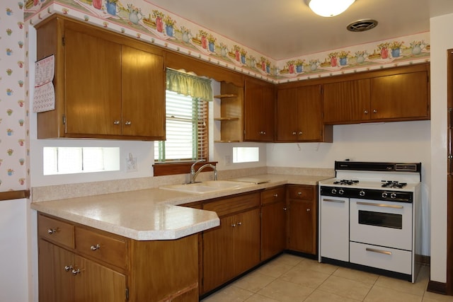 10132 S Fairfield Ave, Chicago, IL 60655 - kitchen featuring white range with gas cooktop, light countertops, open shelves, brown cabinets, and wallpapered walls