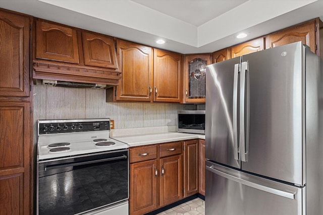103 S Locust St, Loda, IL 60948 - kitchen featuring appliances with stainless steel finishes, brown cabinets, light countertops, custom exhaust hood, and recessed lighting