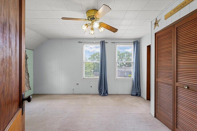 103 S Locust St, Loda, IL 60948 - unfurnished bedroom with carpet flooring, a closet, wood walls, and a ceiling fan