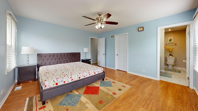 1005 N Dovington Dr, Hoffman Estates, IL 60169 - bedroom featuring wood finished floors, multiple windows, ensuite bath, and a ceiling fan