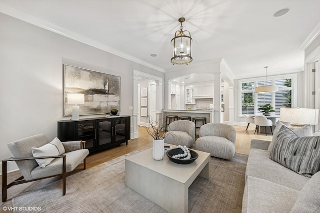 606 S Washington St, Hinsdale, IL 60521 - living area featuring ornate columns, crown molding, wood finished floors, arched walkways, and a chandelier