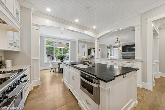 606 S Washington St, Hinsdale, IL 60521 - kitchen with ornate columns, stainless steel appliances, light wood finished floors, ornamental molding, and glass insert cabinets