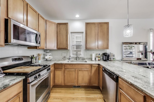 1900 N Laramie Ave, Chicago, IL 60639 - kitchen featuring appliances with stainless steel finishes, light wood-type flooring, light stone counters, and recessed lighting