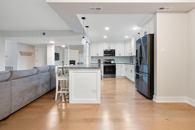 9197 N Rd Unit C, Palos Hills, IL 60465 - kitchen with stainless steel appliances, open floor plan, a breakfast bar area, white cabinets, and recessed lighting