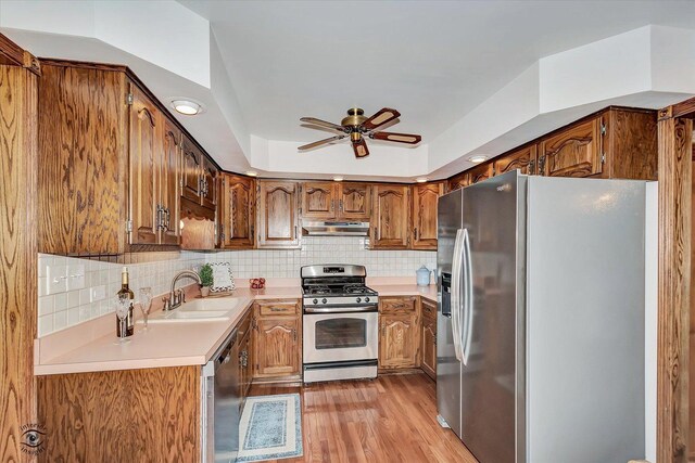 8025 Shoshone Trl, Tinley Park, IL 60477 - kitchen featuring appliances with stainless steel finishes, under cabinet range hood, light wood-style flooring, ceiling fan, and brown cabinets