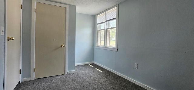 909 W 6th St, Dixon, IL 61021 - unfurnished bedroom featuring a textured ceiling and dark carpet