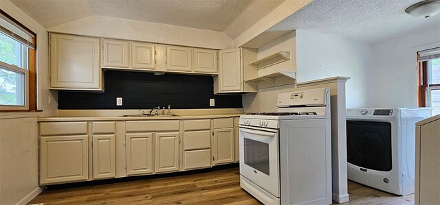909 W 6th St, Dixon, IL 61021 - kitchen with white gas stove, washer / clothes dryer, light wood finished floors, a textured ceiling, and light countertops