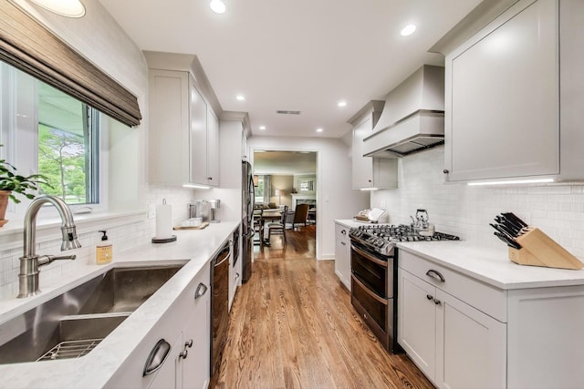 1311 E Woodford Pl, Arlington Heights, IL 60004 - kitchen with double oven range, custom range hood, light wood-type flooring, freestanding refrigerator, and tasteful backsplash