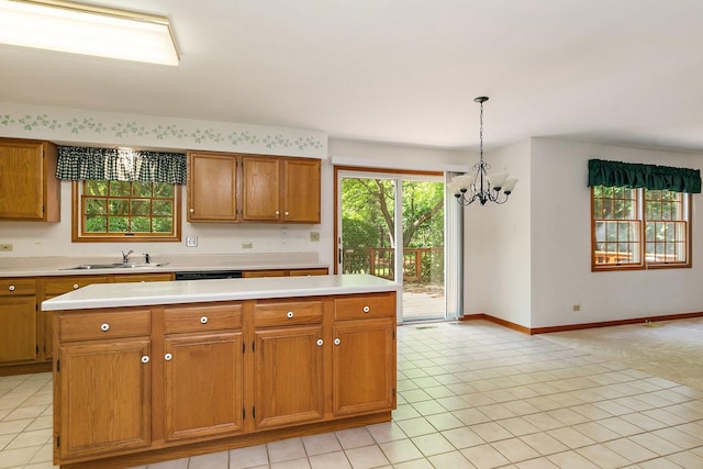 905 Pember Cir, West Dundee, IL 60118 - kitchen with a chandelier, light countertops, brown cabinetry, a kitchen island, and decorative light fixtures