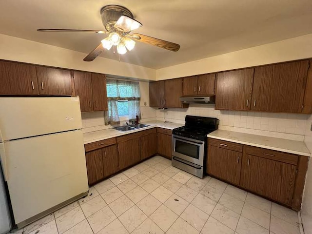 1116 Amherst Ln, University Park, IL 60484 - kitchen with freestanding refrigerator, stainless steel range with gas cooktop, light countertops, under cabinet range hood, and decorative backsplash
