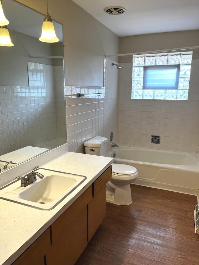 664 E 142nd St, Dolton, IL 60419 - full bathroom featuring wood finished floors, vanity, shower / tub combination, and tile walls
