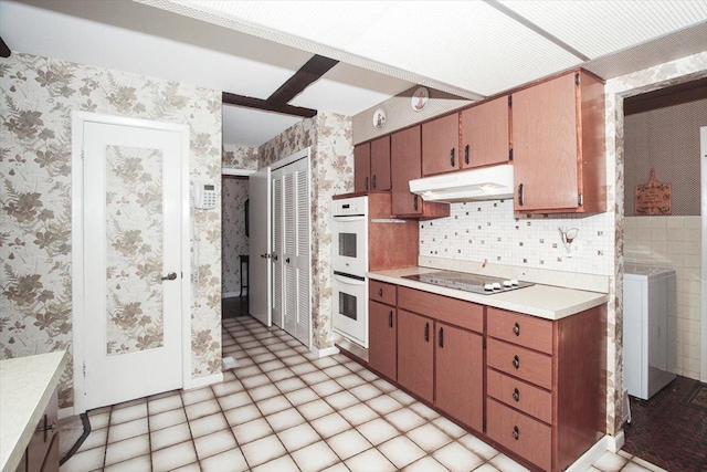69 Grange Rd, Elk Grove Village, IL 60007 - kitchen with under cabinet range hood, black electric cooktop, wallpapered walls, double oven, and light countertops
