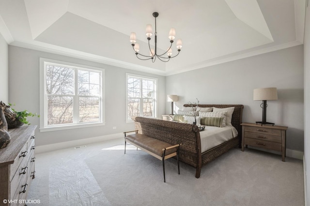 bedroom featuring a tray ceiling, a chandelier, and light carpet