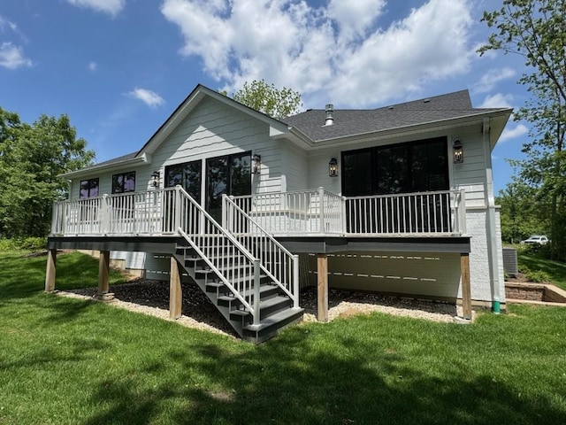 rear view of property with a deck, a yard, and stairway