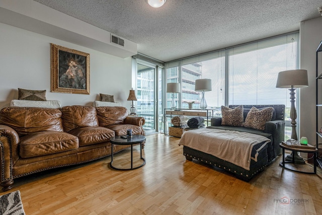 9655 Woods Dr Unit 1009, Skokie, IL 60077 - living room with a wall of windows, wood finished floors, and a textured ceiling