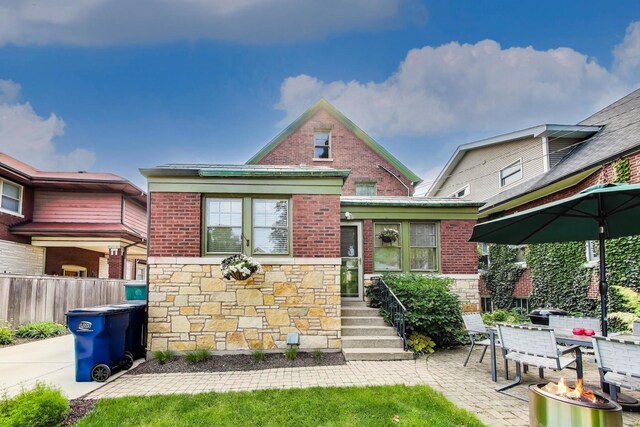 934 Jackson Ave, River Forest, IL 60305 - view of front of house with stone siding, brick siding, an outdoor fire pit, and a patio