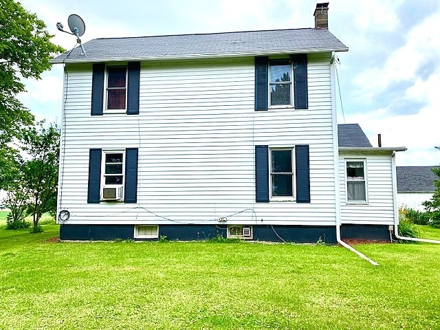 17218 Lincoln Rd, Morrison, IL 61270 - rear view of house featuring a chimney, a lawn, and cooling unit