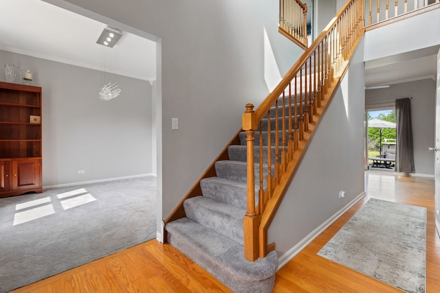 509 Magnolia Dr, North Aurora, IL 60542 - stairs featuring wood finished floors, crown molding, and a chandelier