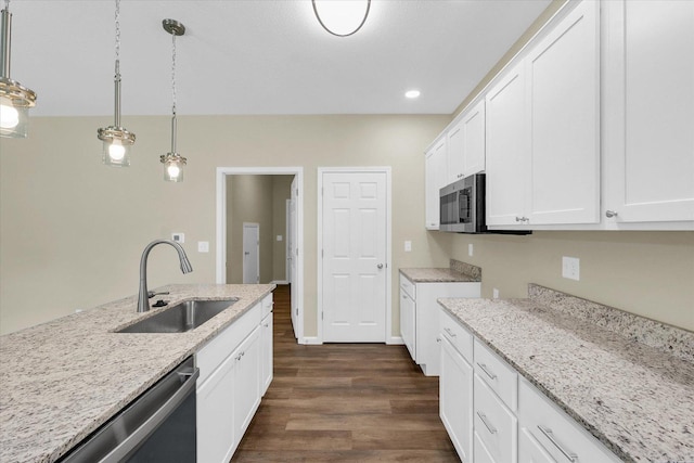 5 Montclair Rd Unit A, Urbana, IL 61801 - kitchen with stainless steel appliances, dark wood-style floors, white cabinets, light stone counters, and pendant lighting