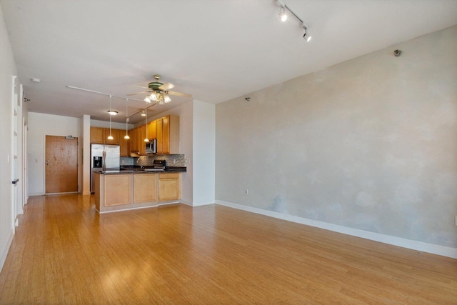 5 E 14th Pl Unit 602, Chicago, IL 60605 - kitchen featuring stainless steel appliances, dark countertops, light wood-type flooring, rail lighting, and a ceiling fan