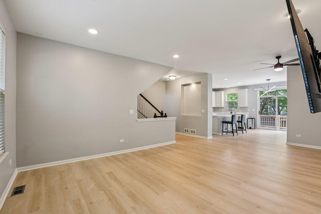 5608 Cambridge Way, Hanover Park, IL 60133 - unfurnished living room with a ceiling fan, light wood-type flooring, stairs, recessed lighting, and a chandelier