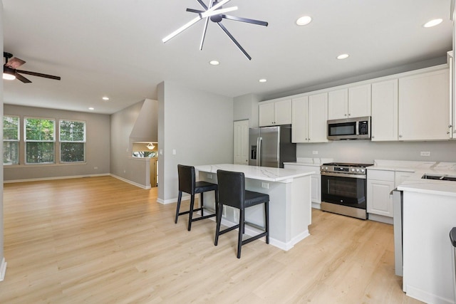 5608 Cambridge Way, Hanover Park, IL 60133 - kitchen with appliances with stainless steel finishes, a ceiling fan, a kitchen island, light wood finished floors, and recessed lighting