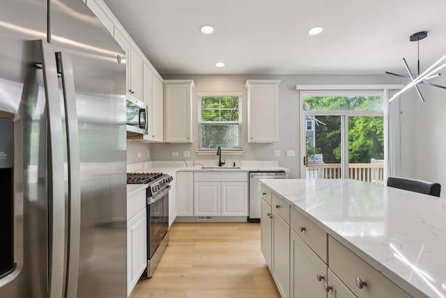 5608 Cambridge Way, Hanover Park, IL 60133 - kitchen with stainless steel appliances, recessed lighting, white cabinets, light wood-type flooring, and light stone countertops