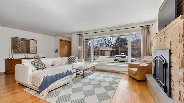 5660 N Rogers Ave, Chicago, IL 60646 - living room featuring light wood finished floors, a fireplace with raised hearth, and crown molding