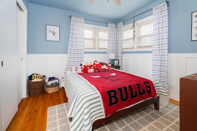 5660 N Rogers Ave, Chicago, IL 60646 - bedroom featuring wood finished floors, a wainscoted wall, a closet, a decorative wall, and ceiling fan