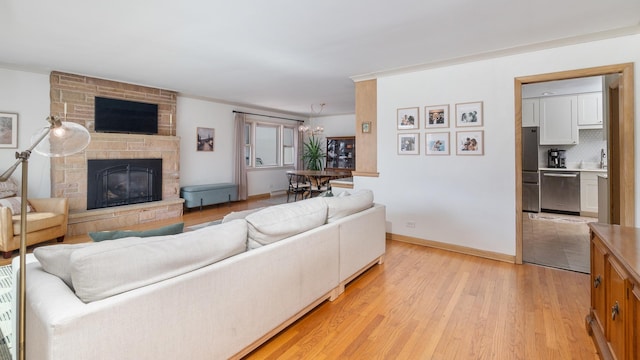 5660 N Rogers Ave, Chicago, IL 60646 - living room featuring light wood-style flooring, a stone fireplace, and ornamental molding