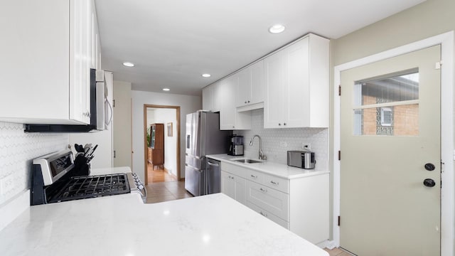 5660 N Rogers Ave, Chicago, IL 60646 - kitchen with appliances with stainless steel finishes, tasteful backsplash, white cabinetry, light countertops, and recessed lighting