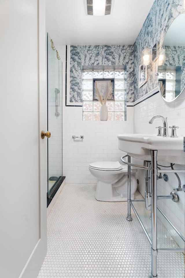 5660 N Rogers Ave, Chicago, IL 60646 - bathroom featuring tile walls, wallpapered walls, a shower stall, tile patterned floors, and wainscoting