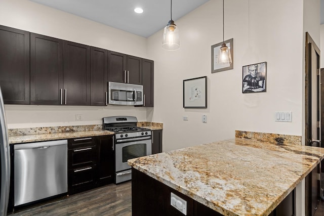 2150 W N Ave Unit 4, Chicago, IL 60647 - kitchen with stainless steel appliances, a peninsula, dark wood-type flooring, light stone counters, and hanging light fixtures
