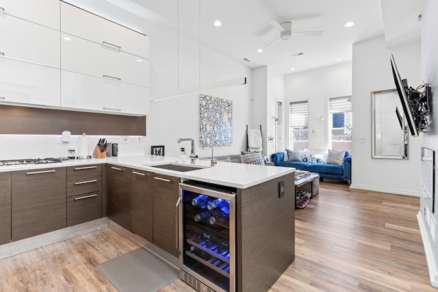 1420 W Fulton St, Chicago, IL 60607 - kitchen with modern cabinets, wine cooler, dark brown cabinets, ceiling fan, and light countertops
