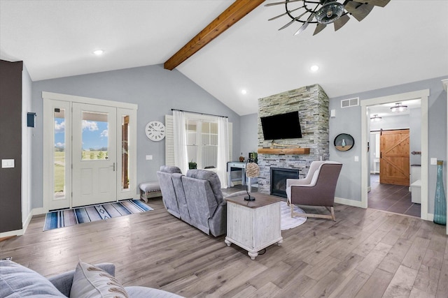 619 County Road 2550 N, Dewey, IL 61840 - living room featuring ceiling fan, a barn door, wood finished floors, and a stone fireplace