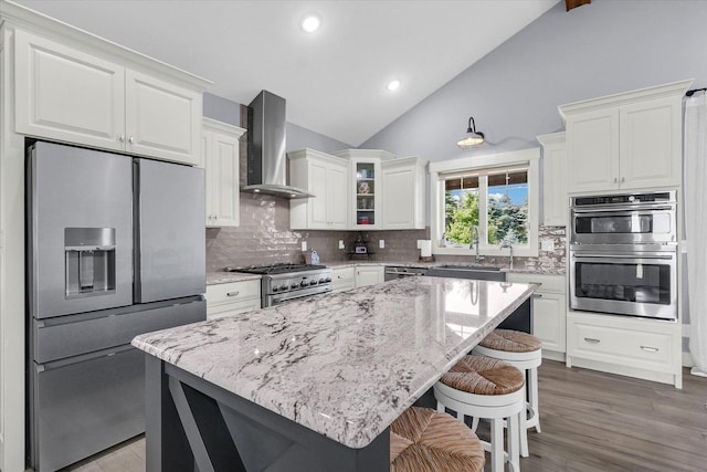 619 County Road 2550 N, Dewey, IL 61840 - kitchen with stainless steel appliances, wall chimney range hood, decorative backsplash, a kitchen bar, and light stone countertops