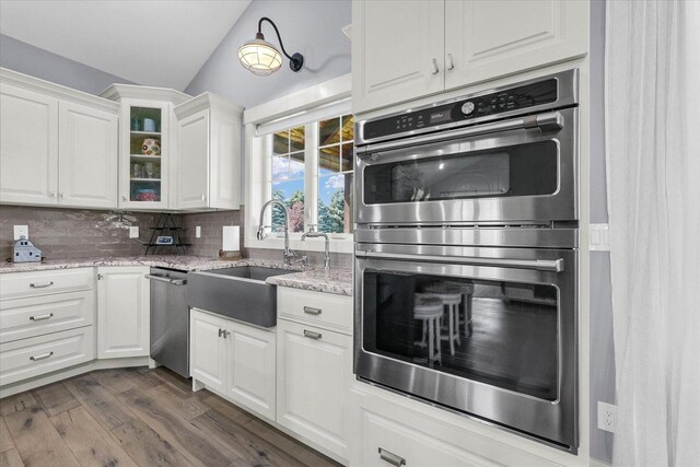 619 County Road 2550 N, Dewey, IL 61840 - kitchen featuring appliances with stainless steel finishes, vaulted ceiling, dark wood finished floors, white cabinets, and glass insert cabinets