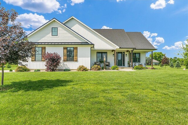 619 County Road 2550 N, Dewey, IL 61840 - modern farmhouse featuring a standing seam roof, a front yard, a porch, and a metal roof