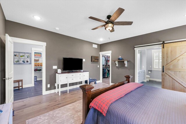 619 County Road 2550 N, Dewey, IL 61840 - bedroom featuring a barn door, light wood finished floors, a spacious closet, a closet, and connected bathroom