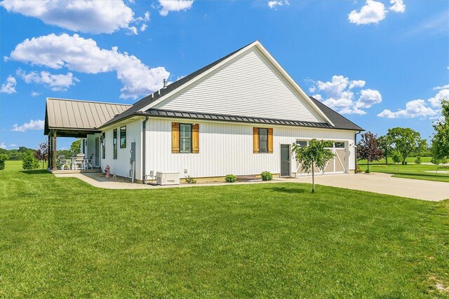 619 County Road 2550 N, Dewey, IL 61840 - view of side of home with a metal roof, a standing seam roof, a lawn, and concrete driveway