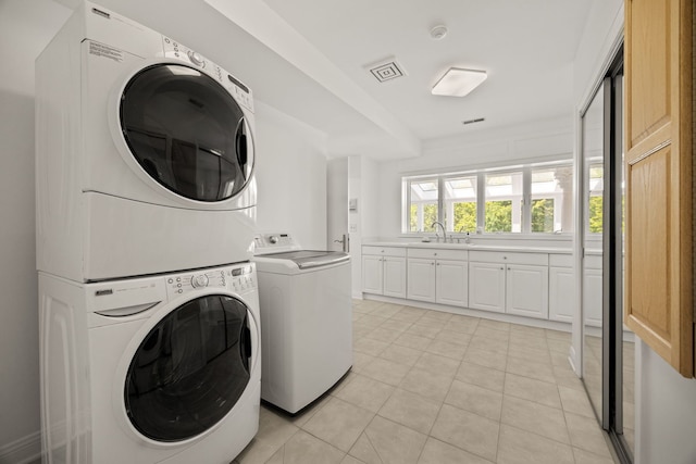 W3318 Lake Forest Ln, Lake Geneva, WI 53147 - laundry area with cabinet space, stacked washer and clothes dryer, and light tile patterned flooring