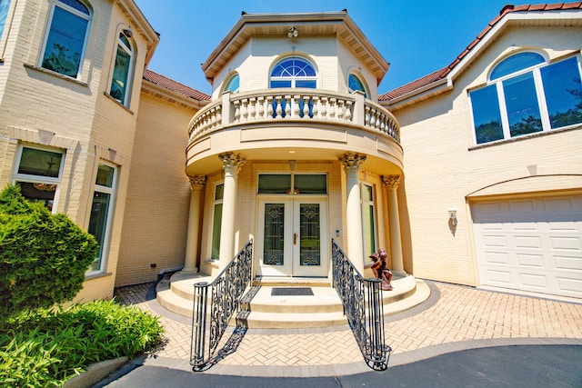 W3318 Lake Forest Ln, Lake Geneva, WI 53147 - doorway to property featuring french doors, a balcony, a garage, and brick siding